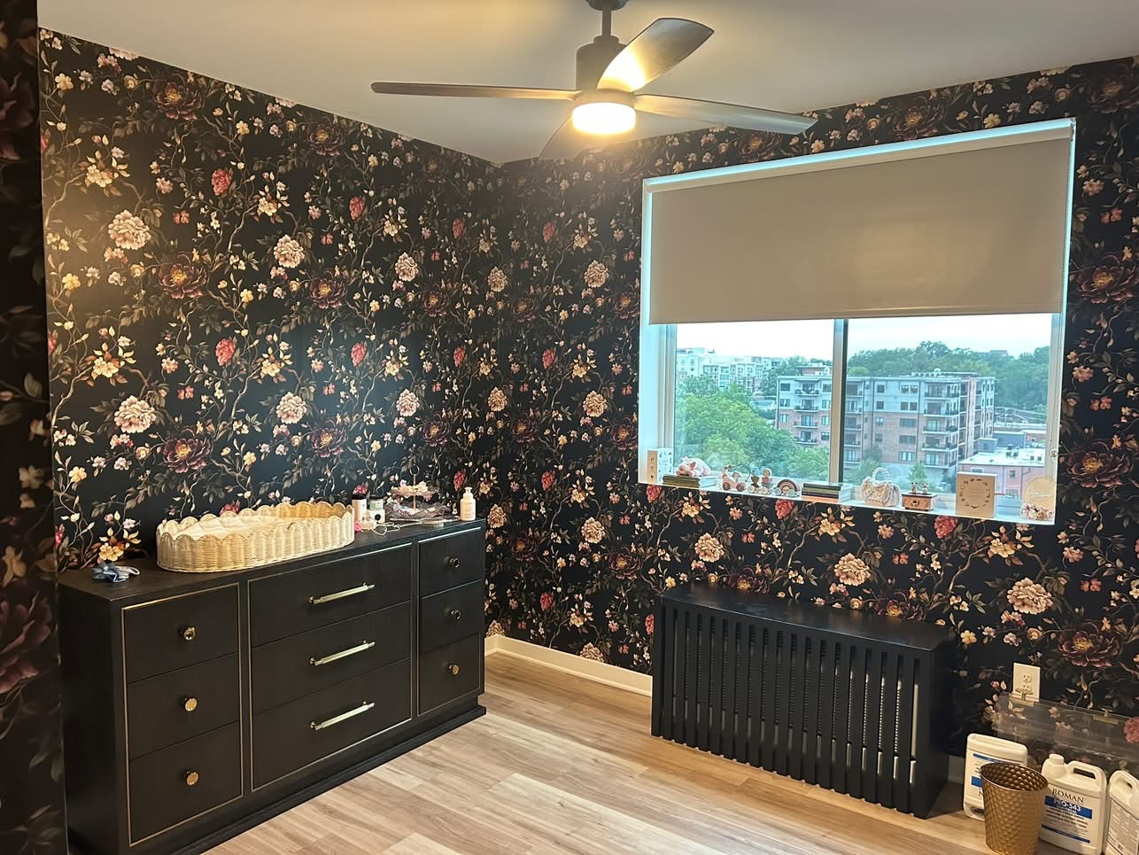 Dark floral wallpaper installation in a bedroom